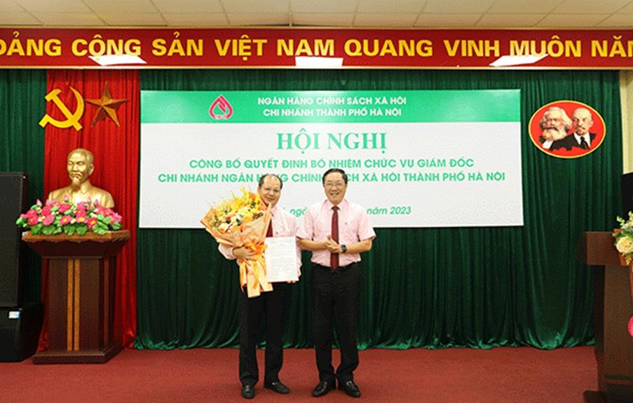 Tổng Giám đốc Dương Quyết Thắng (bên phải) trao Quyết định và tặng hoa chúc mừng Giám đốc Chi nhánh NHCSXH thành phố Hà Nội Phạm Văn Quyết