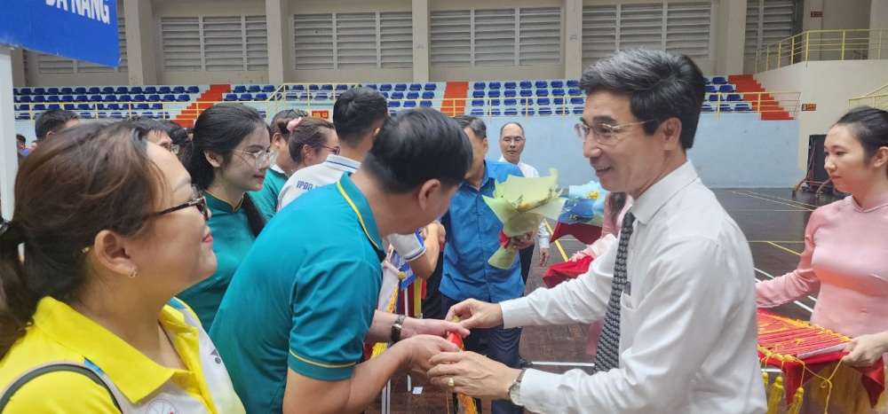 Phó Chủ tịch UBND thành phố Trần Chí Cường (bên phải) tặng cờ lưu niệm cho vận động viên dự hội thao.