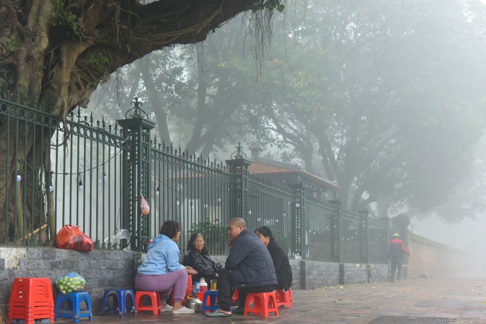 Người dân ngồi trà đá vỉa hè trong sương