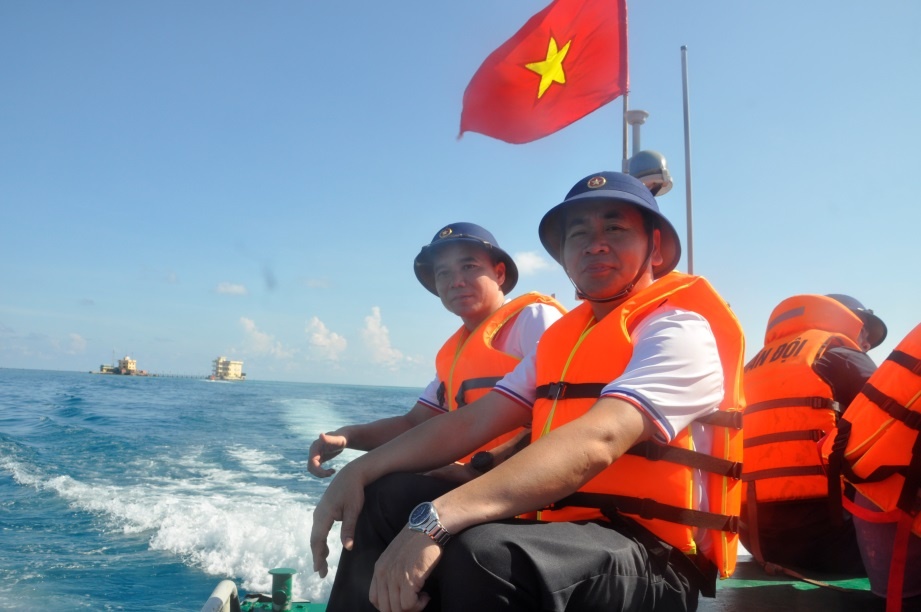 Các thành viên trong đoàn công tác đi ca nô từ tàu vào đảo