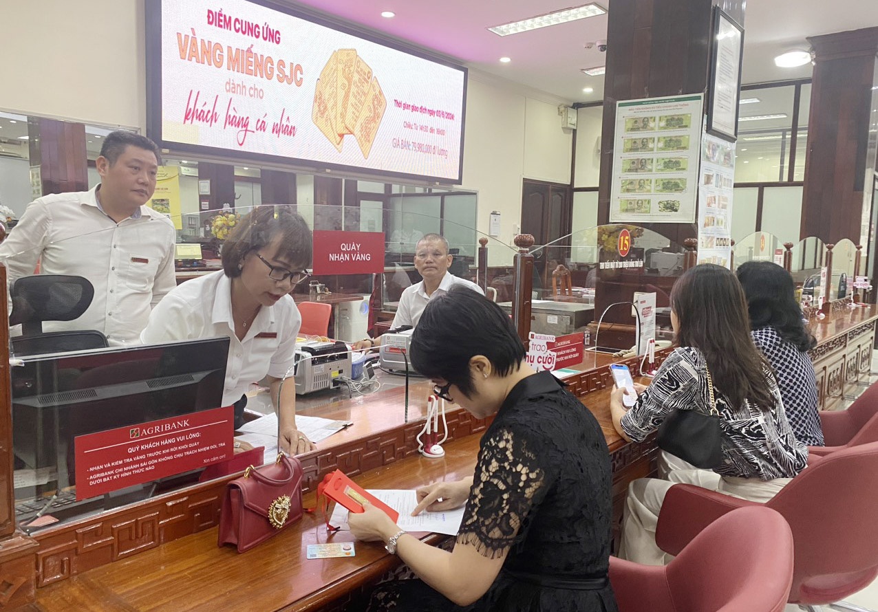 Khách hàng mua vàng miếng SJC tại Agribank Sài Gòn trong ngày đầu bán vàng nhằm kéo giá vàng trong nước xuống tiệm cận giá thế giới - Ảnh: Đình Hải