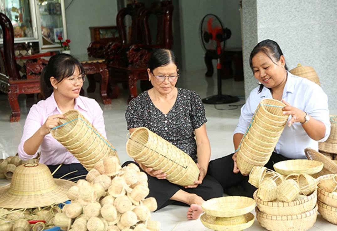 Sản phẩm nông cụ lưu niệm bằng tre đan thu nhỏ tại cơ sở đan lát của bà Diệp Thị Trang (ngồi giữa)