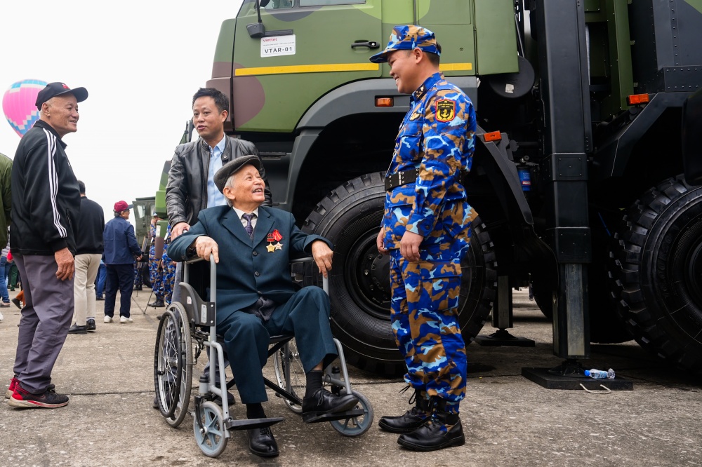 Cụ Trần Bích Duyên cực chiến binh trung đoàn tên lửa đang trao đổi với một chiến sĩ 