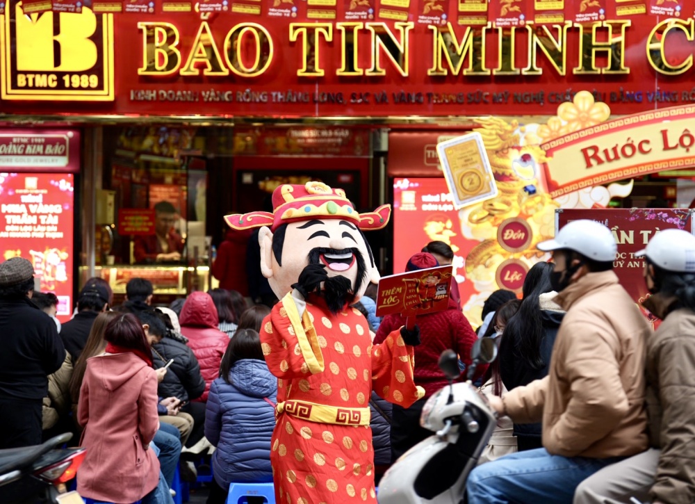 Ông Thần tài tại cửa Bảo Tín Minh Châu đang mời khách vào của hàng