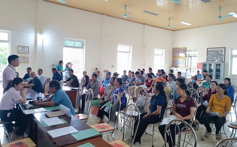 Cán bộ Phòng giao dịch NHCSXH Ba Vì thông tin đến người dân về các chương trình cho vay, phổ biến nội dung và cách thức đối chiếu nợ