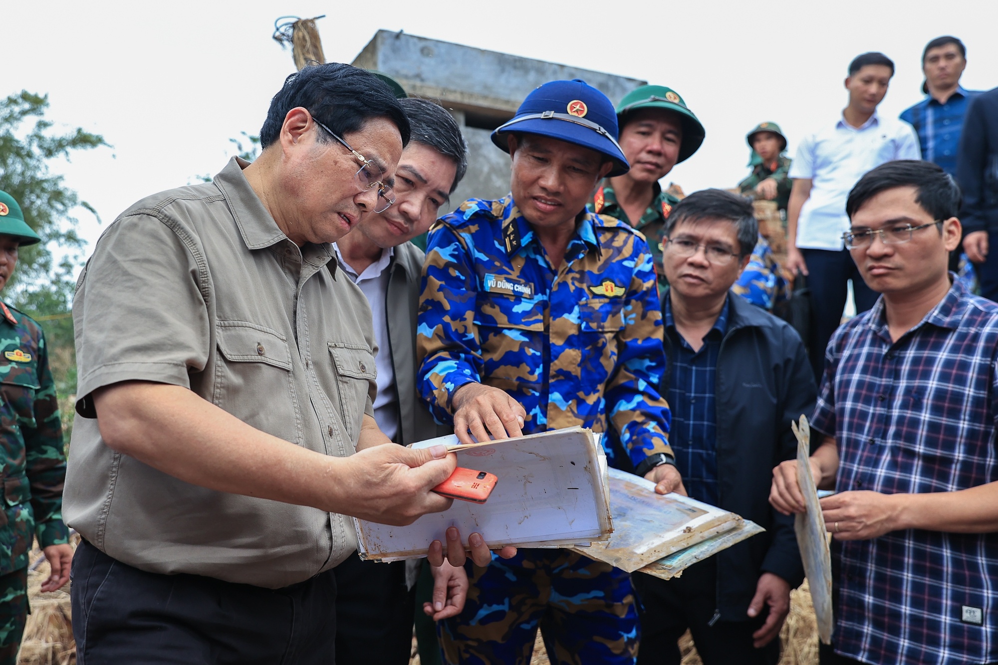 Thủ tướng xúc động xem những vật dụng của người dân còn sót lại sau lũ lụt - Ảnh: VGP/Nhật Bắc