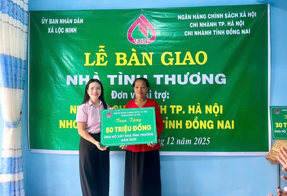 Bà Ngô Thuý Hằng - Chủ tịch CĐCS NHCSXH thành phố Hà Nội trao tiền hỗ trợ xây nhà cho gia đình bà Thị Mai, thôn Lộc Thuận 9, xã Lộc Ninh