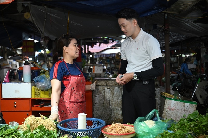 Chị Nguyễn Thị Thu (Chợ Đồng Xa, Hà Nội) được nhân viên VPBank hướng dẫn mở tài khoản hộ kinh doanh ngay tại quầy hàng