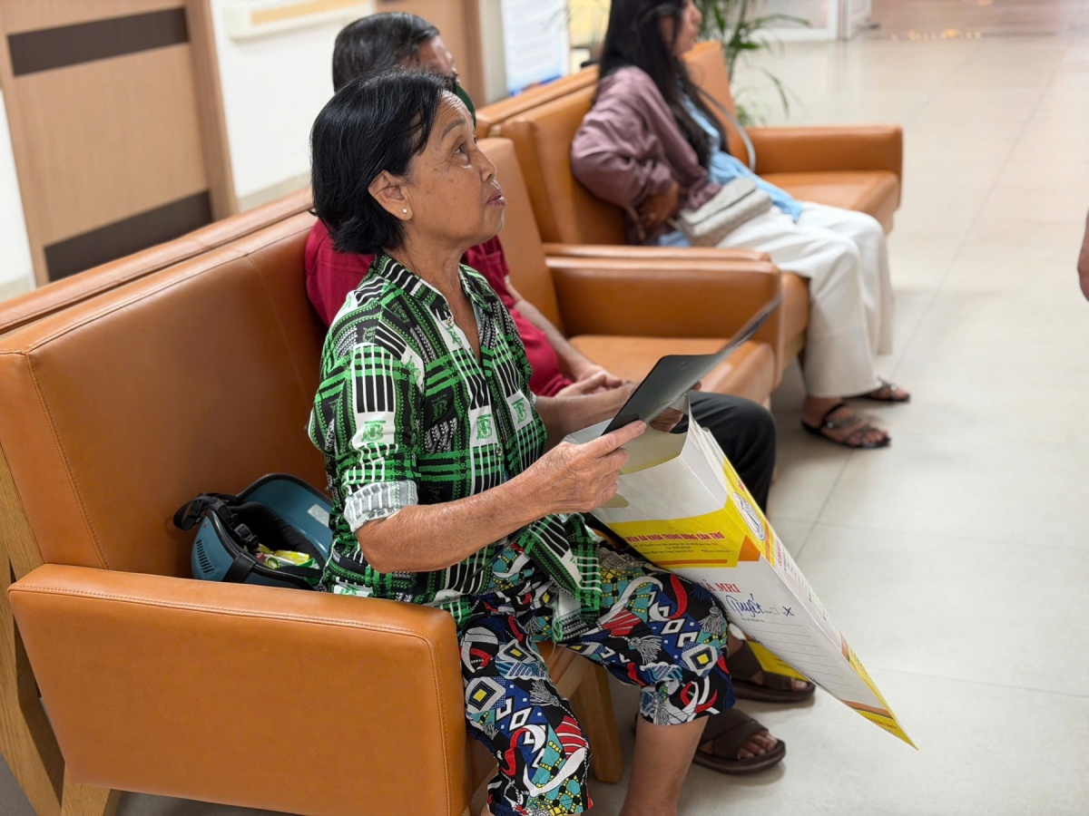Bà Huỳnh Thị Tuyết cầm trên tay hồ sơ bệnh án cũ chờ được thăm khám. Bà Huỳnh Thị Tuyết cầm trên tay hồ sơ bệnh án cũ chờ được thăm khám.