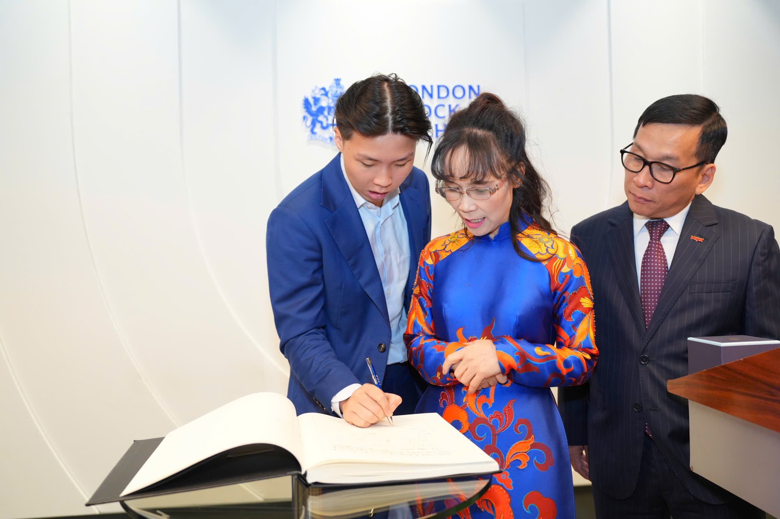 Tiến sĩ Nguyễn Thị Phương Thảo viết sổ lưu niệm sau khi tham dự nghi thức khai phiên giao dịch của LSE Tiến sĩ Nguyễn Thị Phương Thảo viết sổ lưu niệm sau khi tham dự nghi thức khai phiên giao dịch của LSE